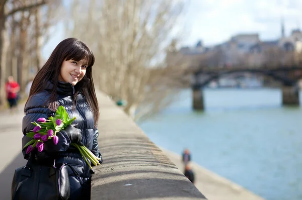 Fröhliche junge Dame in Paris mit schönem Blumenstrauß — Stockfoto