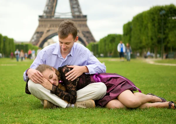 Glückliches romantisches Paar in Paris, im Gras am Eiffelturm sitzend — Stockfoto