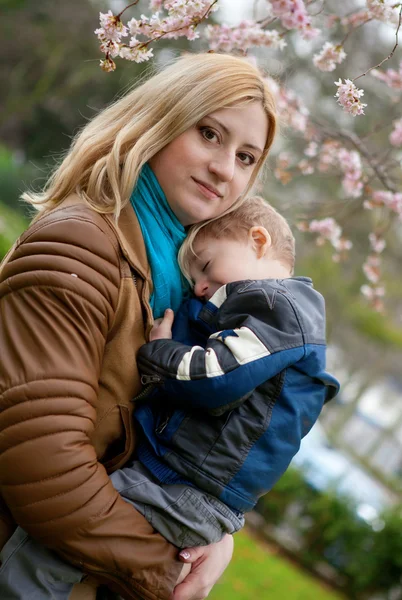 Bella giovane madre con suo figlio in primavera — Foto Stock