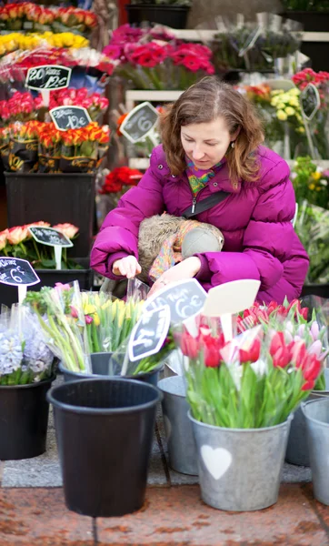 美しい若い女性は市場で花を選択します。 — ストック写真