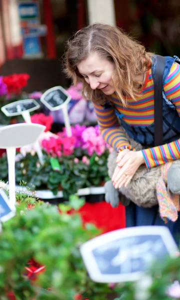 Beautiful young woman selecting flowers at market — Stock Photo, Image