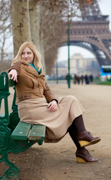 Schöne blonde Frau in Paris, die in der Nähe des Eiffelturms sitzt — Stockfoto