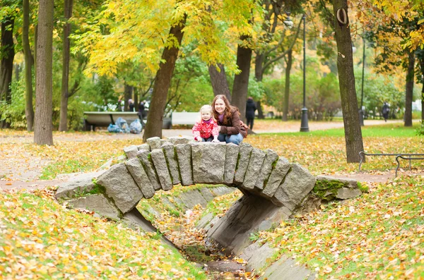 Utomhus porträtt av vackra mor och dotter på en liten br — Stockfoto