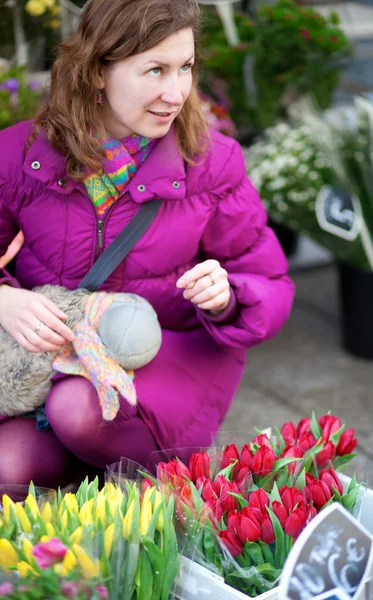 Vacker ung kvinna att välja blommor på marknaden — Stockfoto