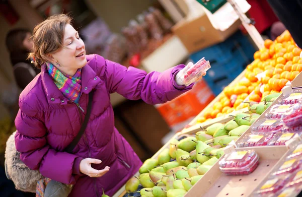 Feliz joven mujer seleccionando frutas en el mercado de frutas —  Fotos de Stock