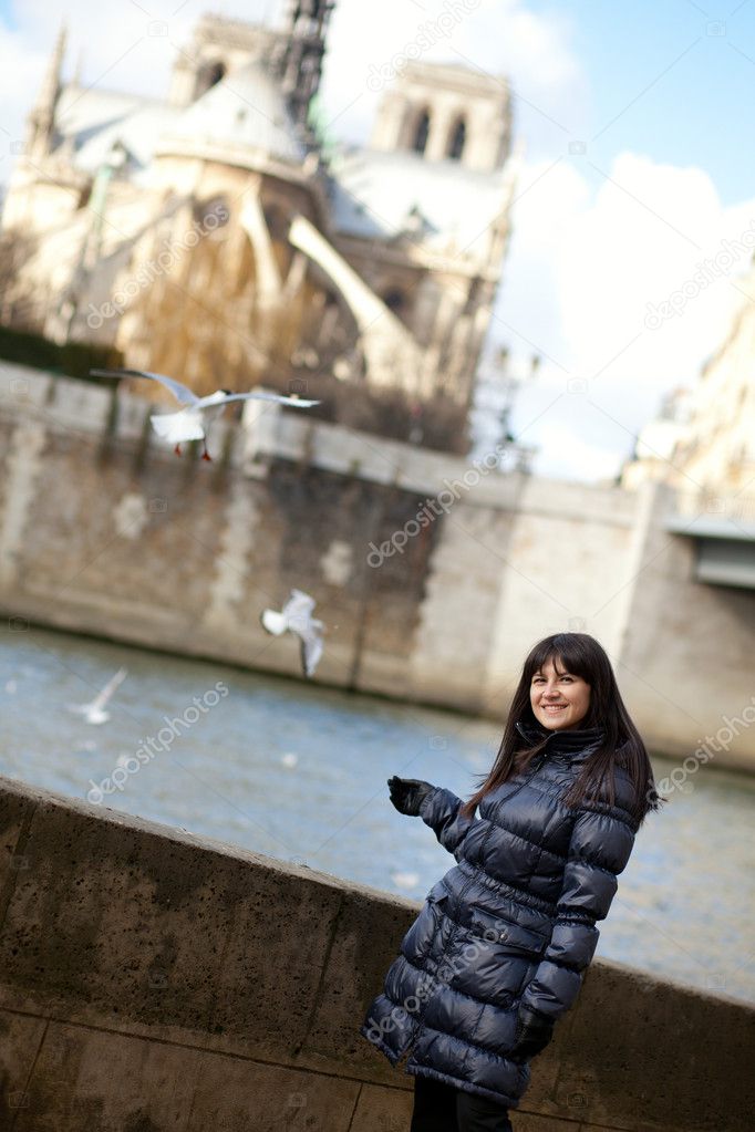 Happy brunette girl at Parisian embankment, sea-gulls flying in