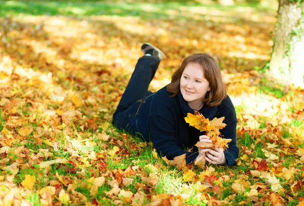 Fille gaie couchée sur le sol dans le parc un jour d'automne — Photo