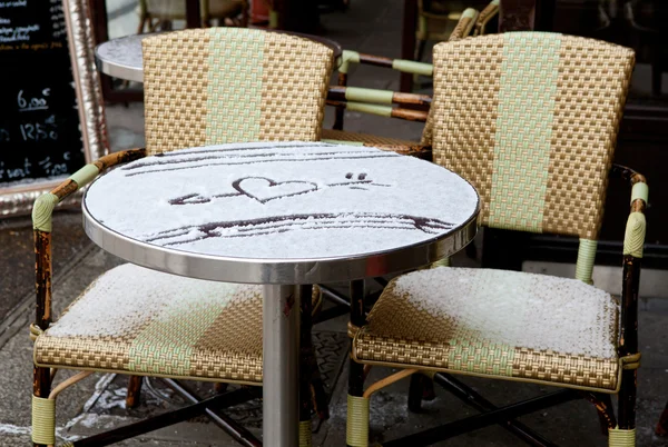 Tisch eines Pariser Straßencafés mit Schnee bedeckt und herzförmig — Stockfoto