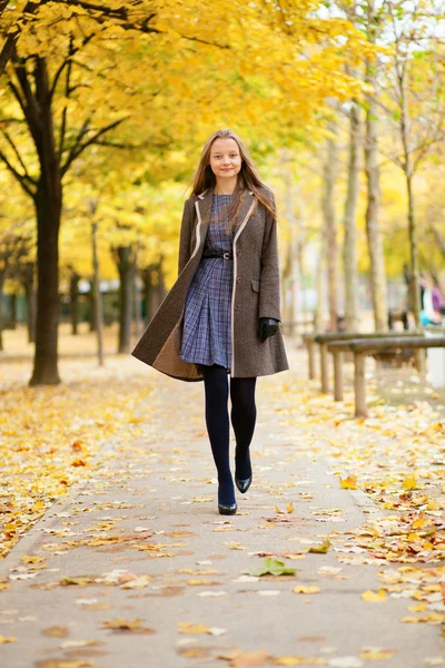Onnellinen kaunis tyttö kävelee puistossa syksyllä päivä — kuvapankkivalokuva