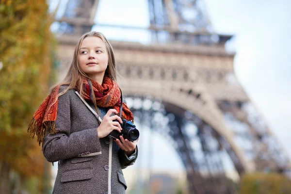 Hermosa chica sosteniendo cámara fotográfica cerca de la torre Eiffel en Par —  Fotos de Stock