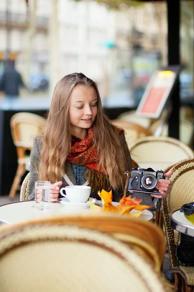 एक कॅफे मध्ये सुंदर तरुण स्त्री एक जुन्या फॅशनेबल फोटो सी धारण — स्टॉक फोटो, इमेज