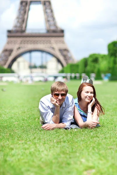 Closeup of happy positive couple laying on the grass near the Ei — Stock Photo, Image