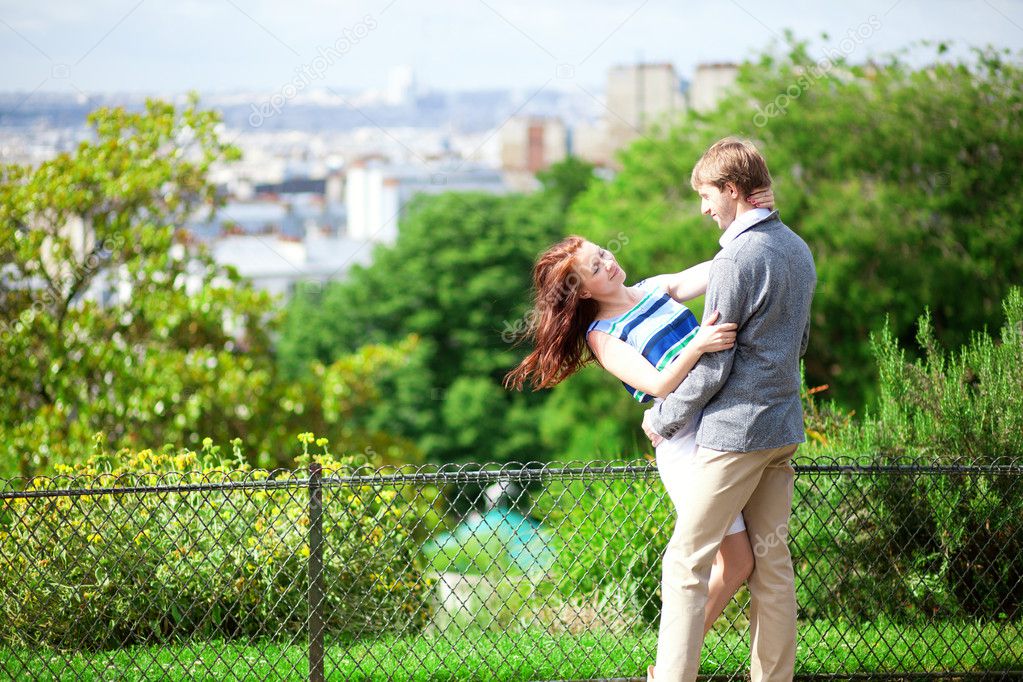 Happy couple is hugging on Montmartre with nice view on Paris