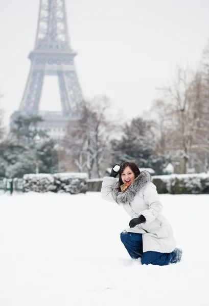 Schönes Mädchen beim Schneeballspielen in der Nähe des Eiffelturms in Paris — Stockfoto