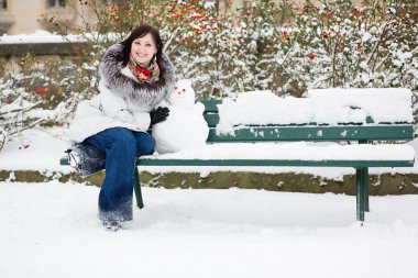 Beautiful smiling girl with a little snowman