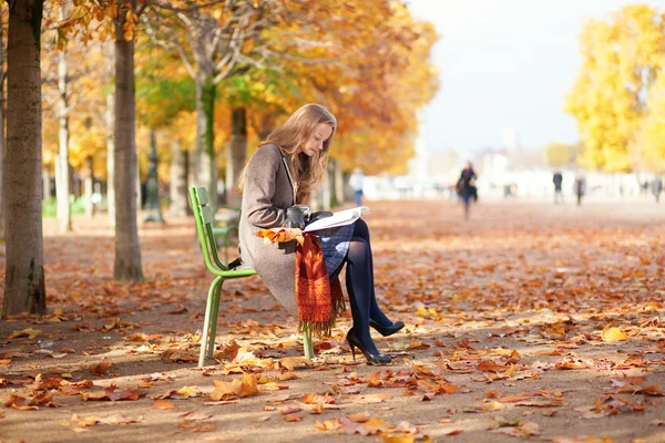 Meisje op een daling dag in park lezen — Stockfoto