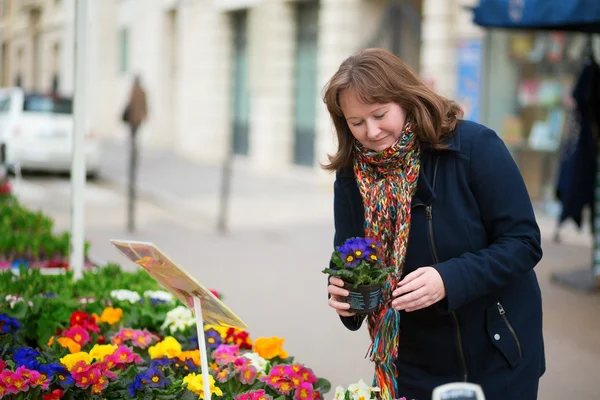 Hermosa mujer comprando flores en un mercado de flores parisino —  Fotos de Stock