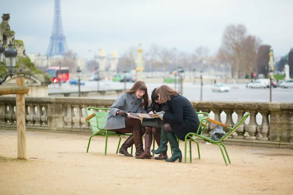 Turistas en París planeando su viaje usando el mapa — Foto de Stock