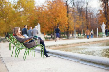 Kız güzel sonbahar günü parkta tadını çıkarıyor.