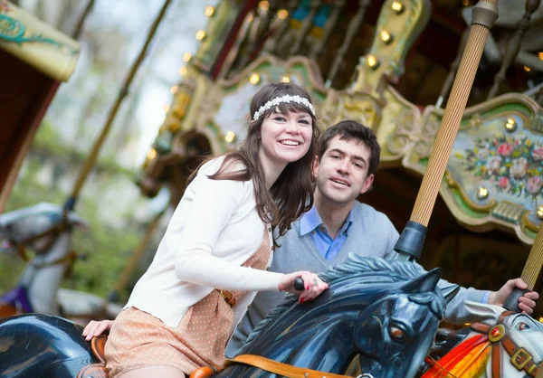 Beautiful couple on a merry-go-round — Stock Photo, Image