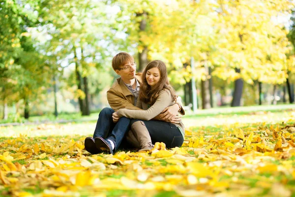 Citas pareja en hojas amarillas en un día de otoño — Foto de Stock