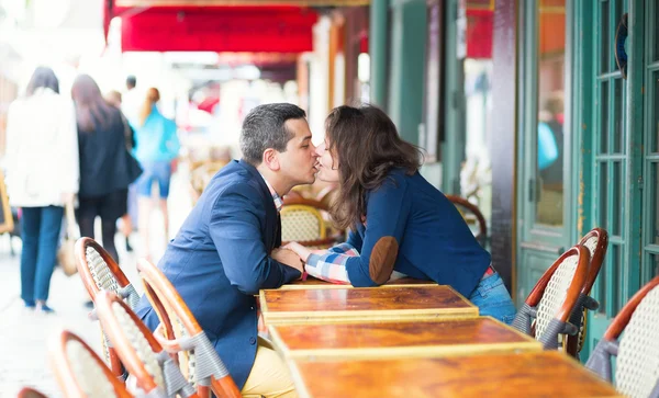 Couple kissing in an outdoor cafe — Stock Photo, Image