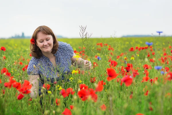 Smiling girl in a beautiful poppy meadow — Stock Photo, Image