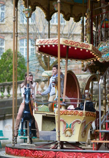 Couple having fun on merry-go-round — Stock Photo, Image