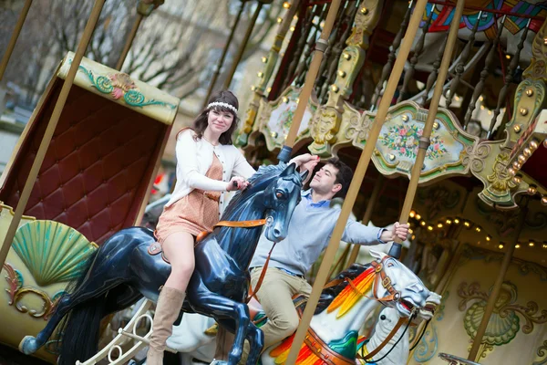 Couple having fun on merry-go-round — Stock Photo, Image