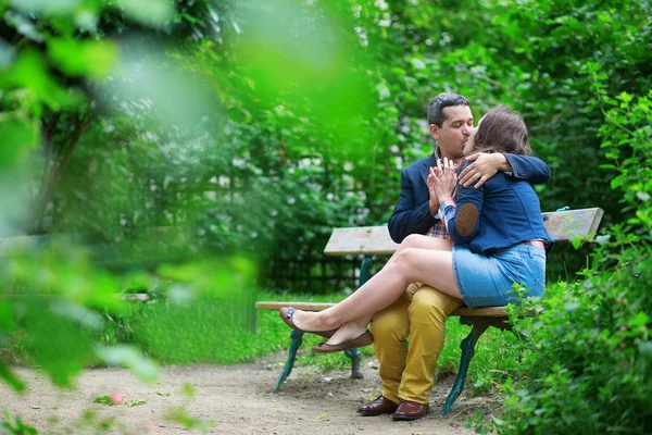 Joven pareja cariñosa besándose en un banco —  Fotos de Stock