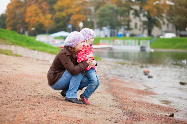 Mother and daughter together on beach by fall — Stock Photo, Image