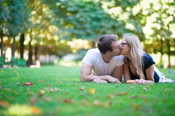 Couple couché sur l'herbe et embrasser — Photo