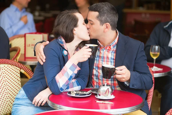 Casal em um café de rua parisiense, beijando — Fotografia de Stock
