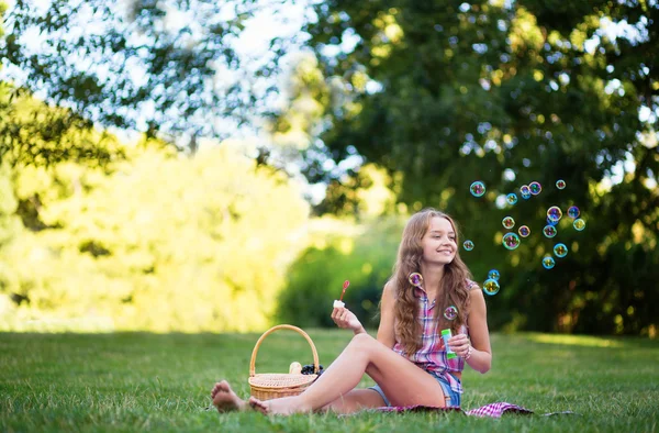 Nuori tyttö puhaltaa kuplia — kuvapankkivalokuva