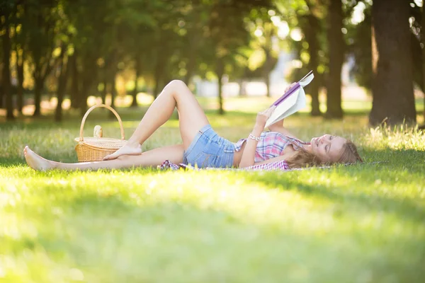 Fille lisant un livre dans le parc — Photo