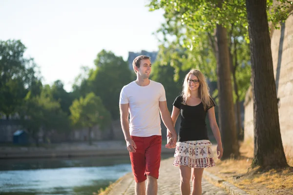 Pareja feliz caminando sobre un terraplén parisino —  Fotos de Stock