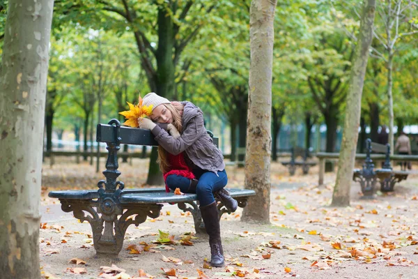 Ledsen flicka sitter på en bänk i parken — Stockfoto