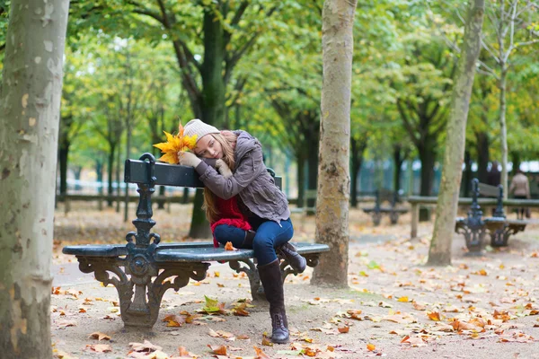 Menina triste sentado em um banco no parque — Fotografia de Stock