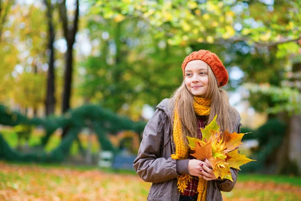 Веселая девушка с кучей листьев — стоковое фото