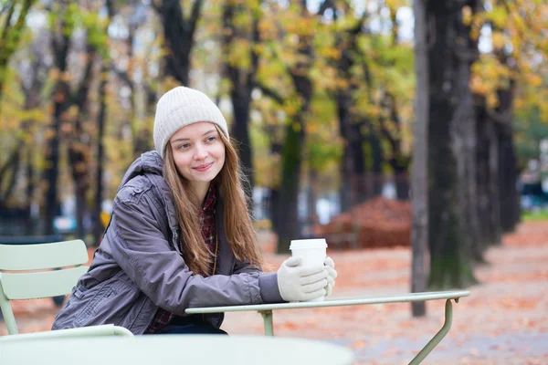 Tyttö juo kahvia ulkona kahvilassa — kuvapankkivalokuva