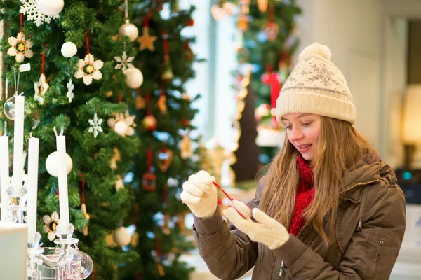 Ragazza che seleziona la decorazione su un mercatino di Natale — Foto Stock