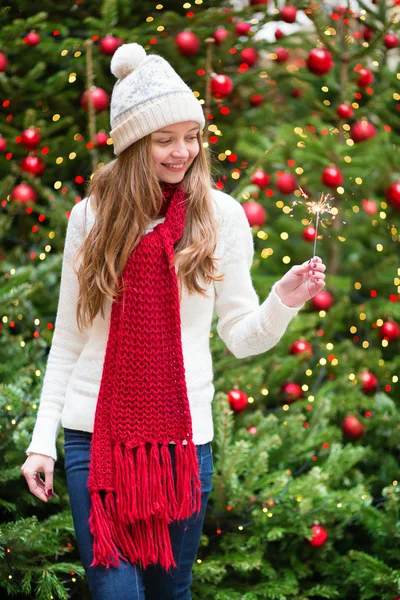 Chica con un bengala cerca del árbol de Navidad — Foto de Stock