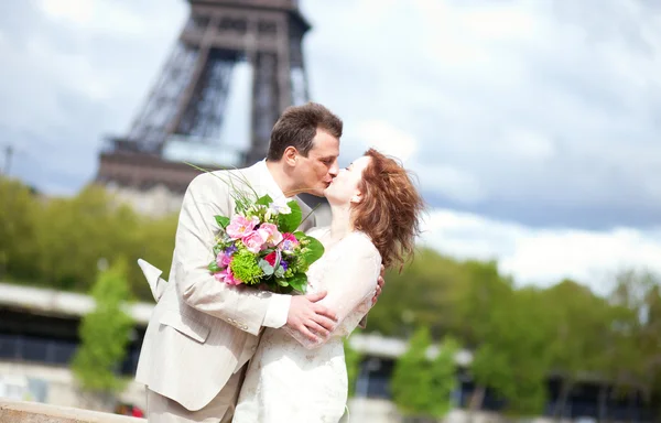 Couple nouvellement marié s'embrassant près de la tour Eiffel — Photo