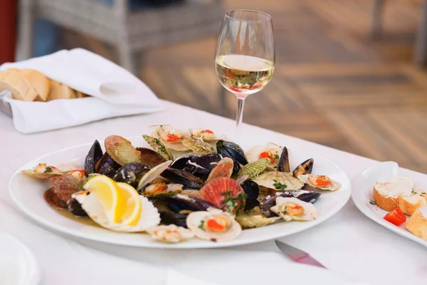 Вкусные моллюски и бокал белого вина — стоковое фото