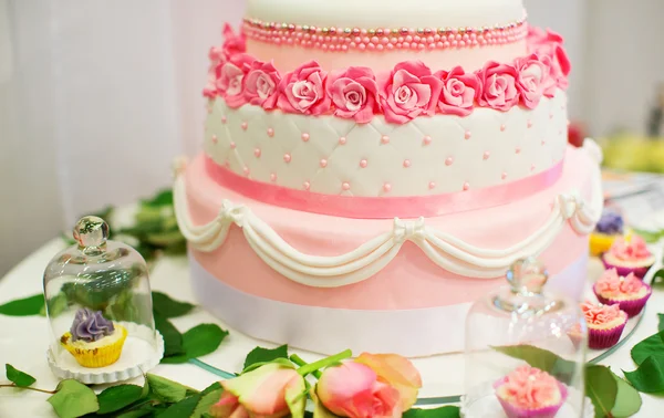 ピンクのバラで飾られた結婚式のケーキ — ストック写真