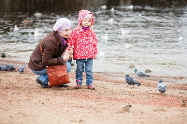 Anya és lánya a strandon keresi a madarak — Stock Fotó