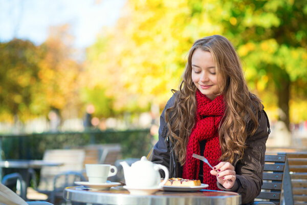 Girl eating waffles in a Parisian outdoor cafe