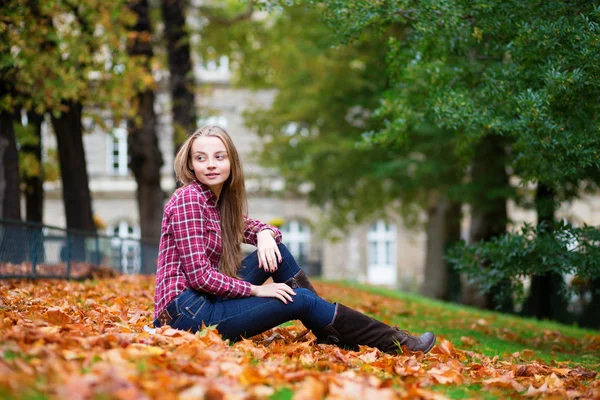 Thoughtful girl sitting on the ground at fall — Stock Photo, Image