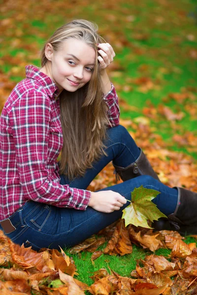 Zamyšlená dívka sedící na zemi na podzim — Stock fotografie