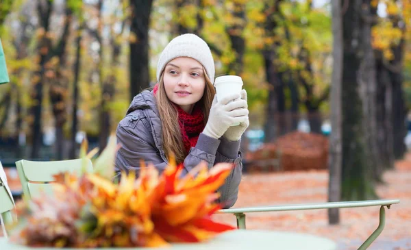 Girl drinking coffee in an outdoor cafe — Stock Photo, Image